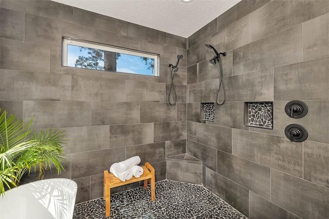 bathroom featuring a tile shower and a textured ceiling