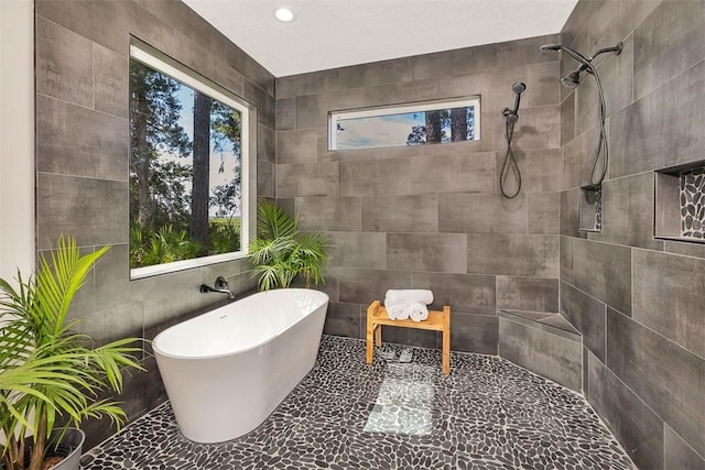 bathroom featuring independent shower and bath and tile walls