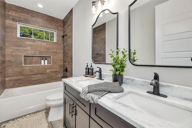 full bathroom with tile patterned flooring, a textured ceiling, toilet, vanity, and tiled shower / bath