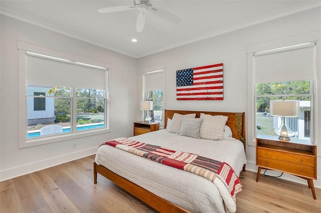 bedroom with hardwood / wood-style flooring, multiple windows, crown molding, and ceiling fan