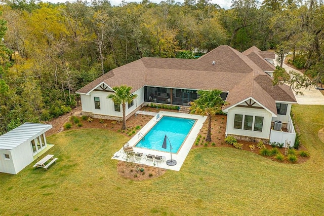 view of swimming pool featuring a patio area, a yard, and an outbuilding