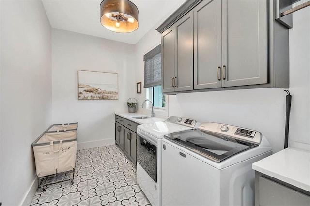 laundry room with cabinets, washer and dryer, and sink