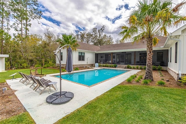 view of swimming pool with a lawn, a patio area, and a sunroom