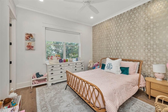 bedroom featuring ceiling fan, ornamental molding, and light wood-type flooring