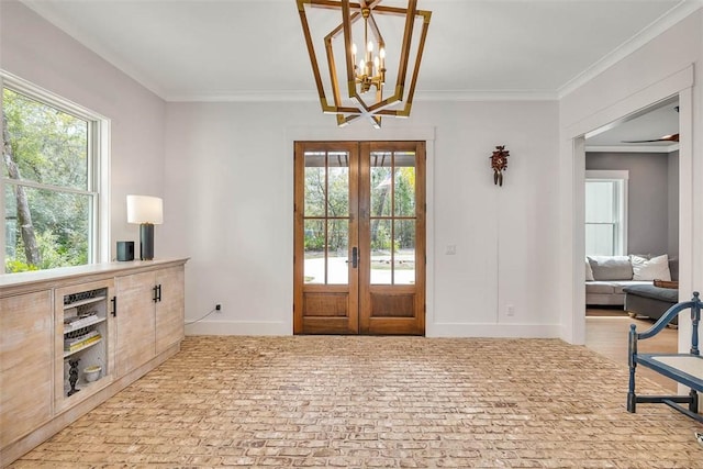 entrance foyer featuring an inviting chandelier, ornamental molding, and french doors