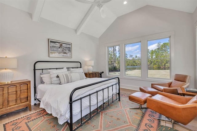 bedroom featuring vaulted ceiling with beams, ceiling fan, and light hardwood / wood-style flooring