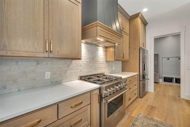 kitchen with premium appliances, light hardwood / wood-style floors, custom range hood, and tasteful backsplash