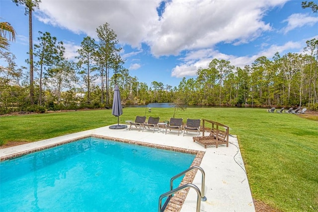 view of pool with a lawn, a water view, and a patio