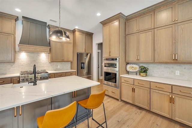 kitchen featuring stainless steel appliances, hanging light fixtures, light hardwood / wood-style floors, decorative backsplash, and custom range hood