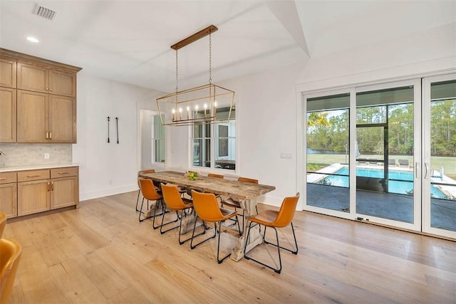 dining area with a chandelier and light hardwood / wood-style flooring