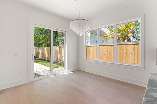 98 Thompson Cv, Saint Simons Island, GA 31522 - unfurnished dining area featuring light wood finished floors, a chandelier, and baseboards