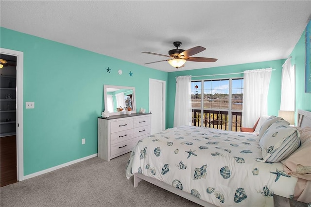 bedroom featuring access to outside, baseboards, a textured ceiling, and light colored carpet