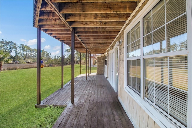 wooden terrace featuring a lawn