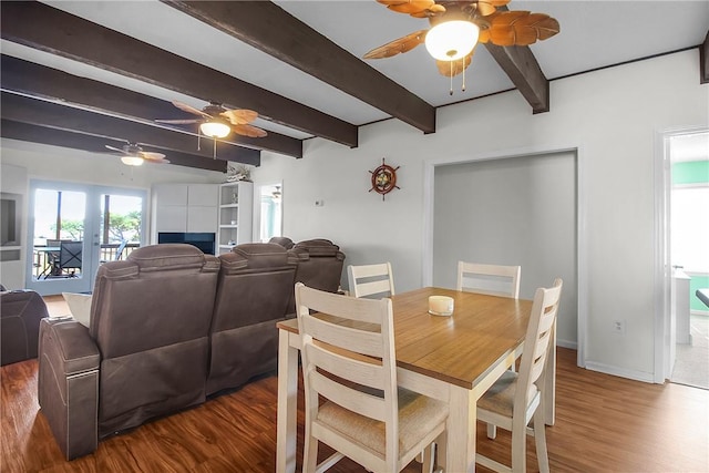 dining space featuring wood finished floors, a ceiling fan, baseboards, french doors, and beamed ceiling