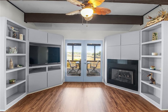 unfurnished living room featuring french doors, a fireplace, a ceiling fan, wood finished floors, and beamed ceiling