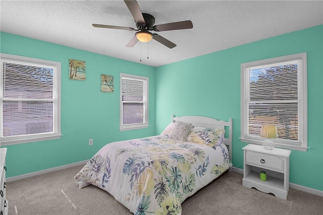 bedroom featuring light carpet, ceiling fan, a textured ceiling, and baseboards