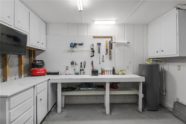 kitchen featuring light countertops, concrete floors, gas water heater, and white cabinetry