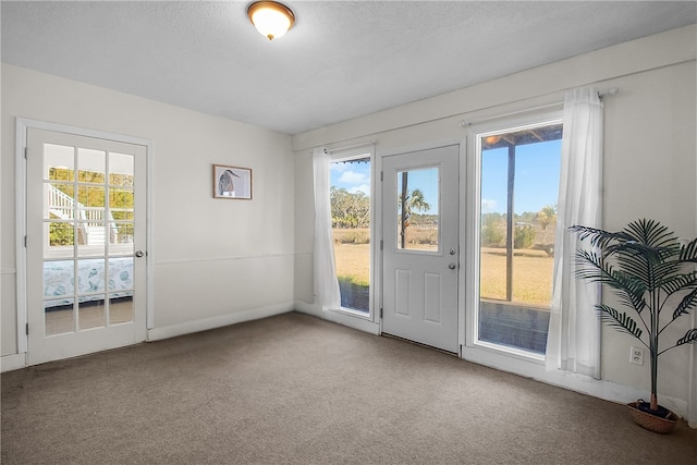 entryway featuring a textured ceiling and carpet floors