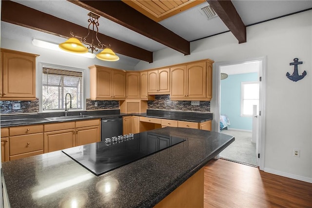 kitchen with dark countertops, a sink, and dishwashing machine