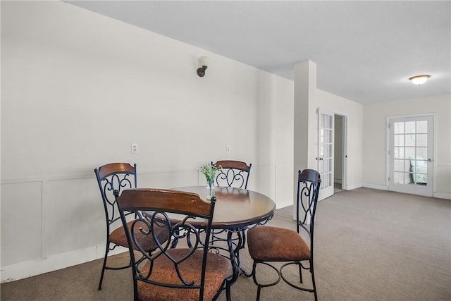 dining room with carpet floors and a decorative wall