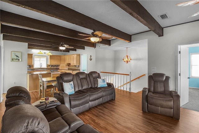 living room with wood finished floors, visible vents, and a healthy amount of sunlight