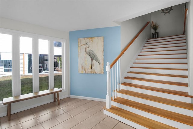 stairway with tile patterned flooring and baseboards