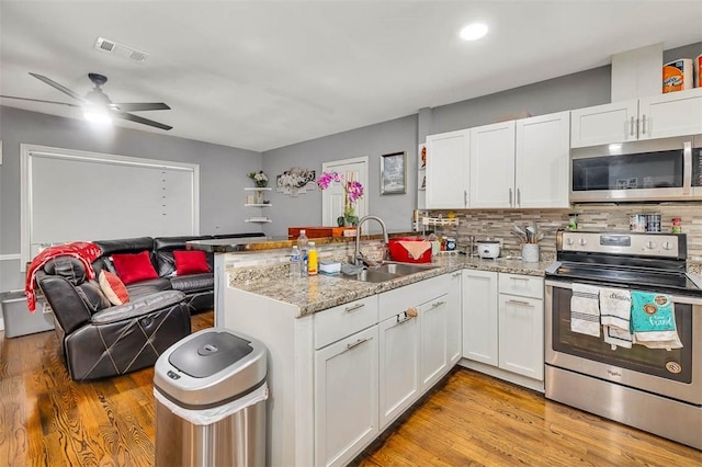 kitchen featuring sink, white cabinets, stainless steel appliances, and light hardwood / wood-style flooring