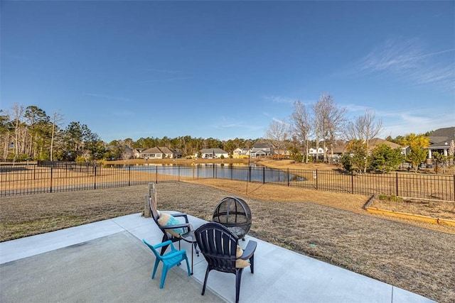 view of patio with a fire pit and a water view