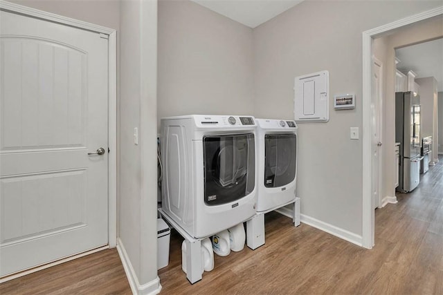 laundry room with light hardwood / wood-style floors and washer and dryer