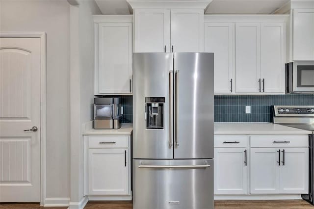 kitchen with stainless steel appliances, white cabinetry, and tasteful backsplash