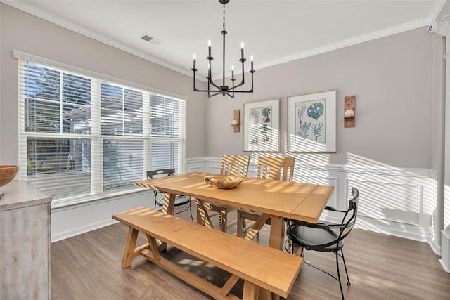 dining space with crown molding, dark wood-type flooring, and a chandelier