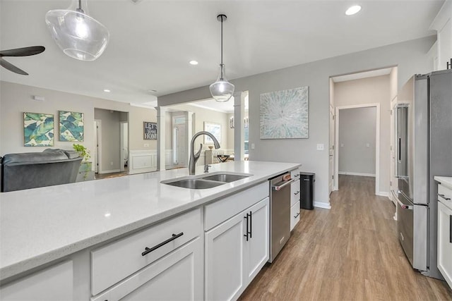 kitchen featuring pendant lighting, white cabinetry, appliances with stainless steel finishes, and sink