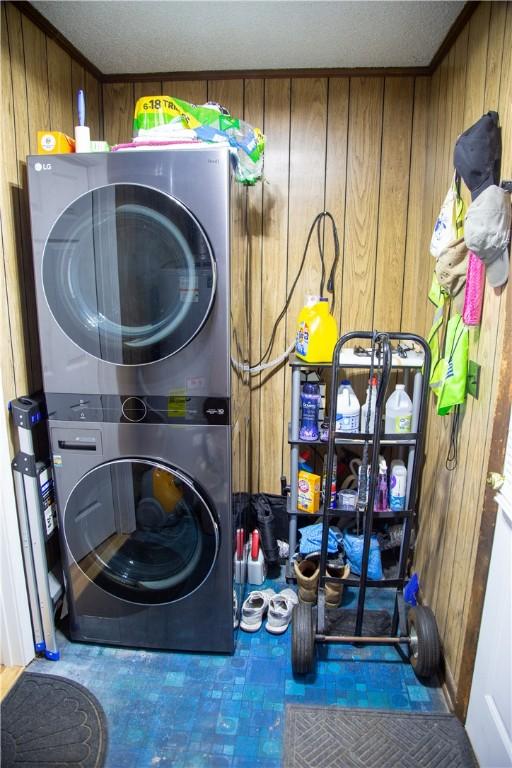 320 Brobston St, Baxley, GA 31513 - washroom with stacked washer / dryer, wood walls, and tile patterned floors