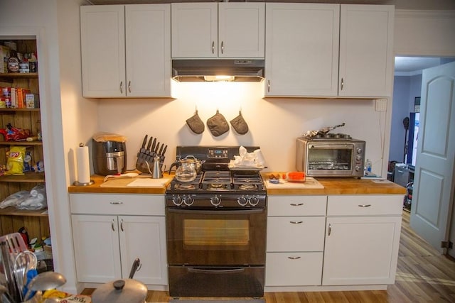 320 Brobston St, Baxley, GA 31513 - kitchen featuring under cabinet range hood, gas stove, butcher block countertops, white cabinetry, and wood finished floors