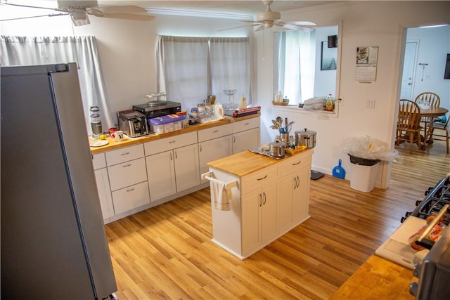 320 Brobston St, Baxley, GA 31513 - kitchen with butcher block countertops, freestanding refrigerator, a ceiling fan, white cabinetry, and light wood finished floors