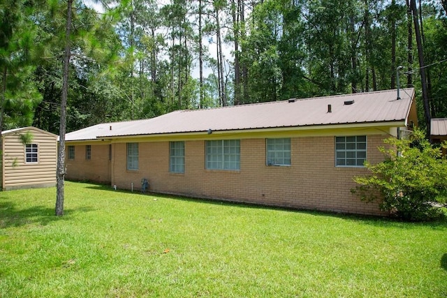 320 Brobston St, Baxley, GA 31513 - back of house featuring a yard, a metal roof, brick siding, and a shed