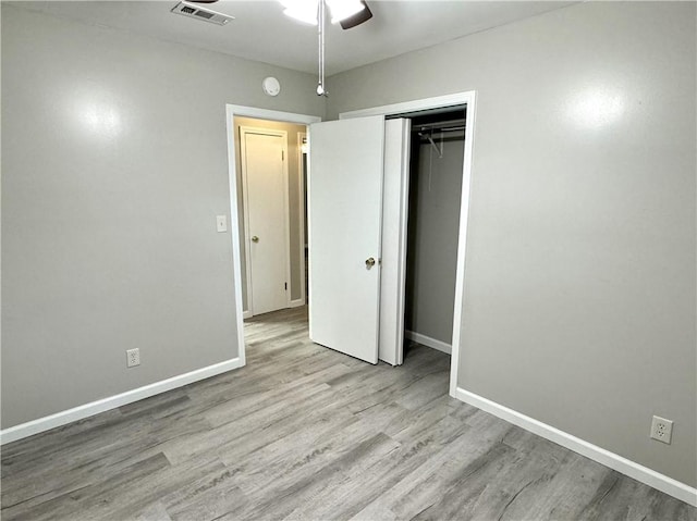 unfurnished bedroom featuring ceiling fan, a closet, and light hardwood / wood-style floors