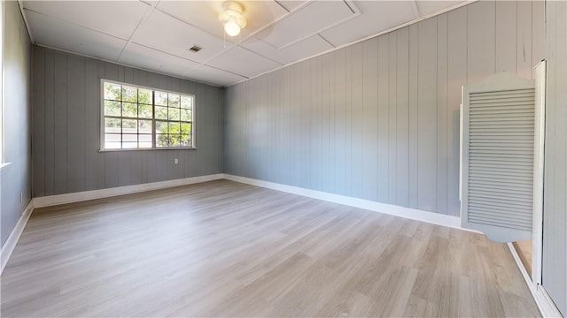 1301 Riverside Ave, Waycross, GA 31501 - unfurnished room with light wood-style floors, baseboards, and wooden walls