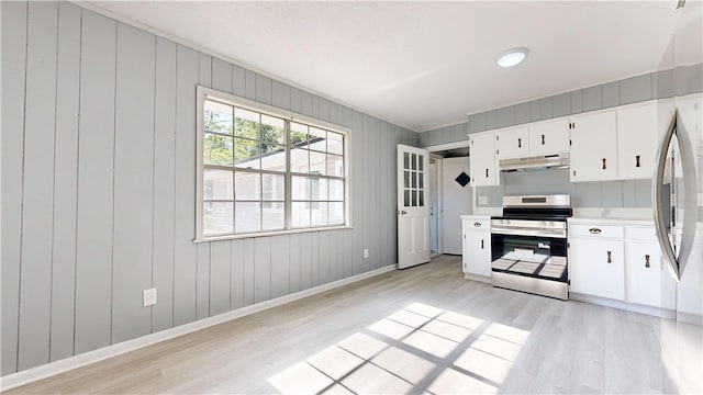 1301 Riverside Ave, Waycross, GA 31501 - kitchen with stainless steel range with electric stovetop, under cabinet range hood, light wood-type flooring, light countertops, and baseboards