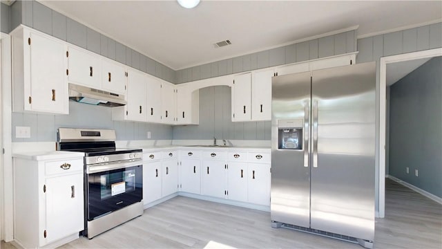 1301 Riverside Ave, Waycross, GA 31501 - kitchen with stainless steel appliances, under cabinet range hood, light wood-style floors, light countertops, and ornamental molding