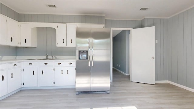 1301 Riverside Ave, Waycross, GA 31501 - kitchen with stainless steel refrigerator with ice dispenser, light wood finished floors, light countertops, a sink, and white cabinets
