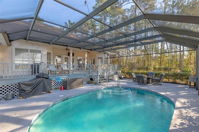 view of pool featuring ceiling fan, a lanai, a deck, and a patio area