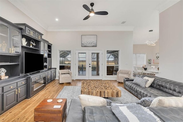 living room featuring french doors, ceiling fan, crown molding, and light hardwood / wood-style floors