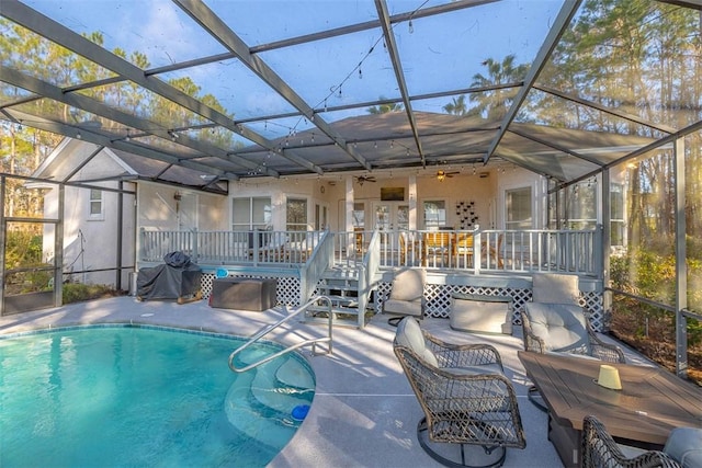 view of swimming pool featuring a lanai, a deck, and ceiling fan