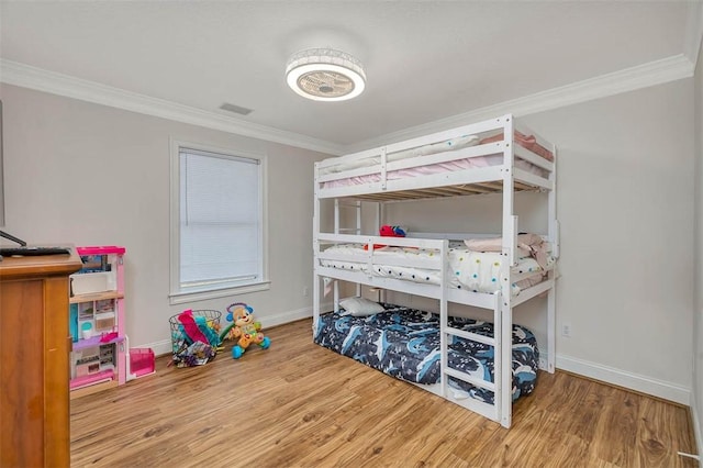 bedroom with crown molding and hardwood / wood-style floors