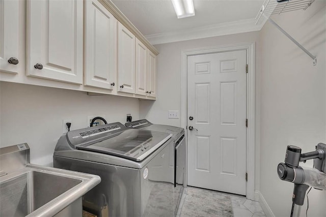 laundry area featuring cabinets, ornamental molding, separate washer and dryer, and sink