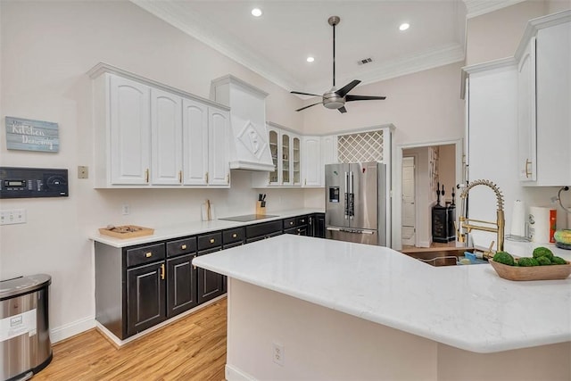 kitchen featuring high quality fridge, sink, white cabinets, ornamental molding, and black electric cooktop