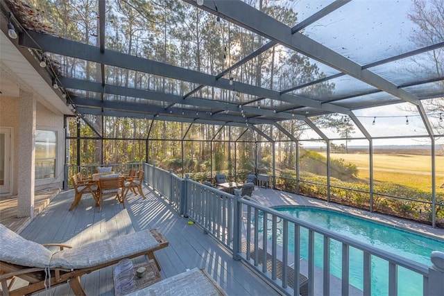 view of swimming pool featuring glass enclosure