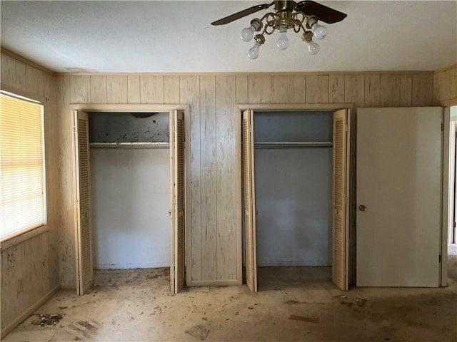 2608 Winchester Dr, Waycross, GA 31501 - unfurnished bedroom with multiple closets, wood walls, and ceiling fan