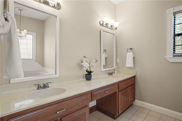 bathroom featuring tile patterned flooring, vanity, a healthy amount of sunlight, and a notable chandelier